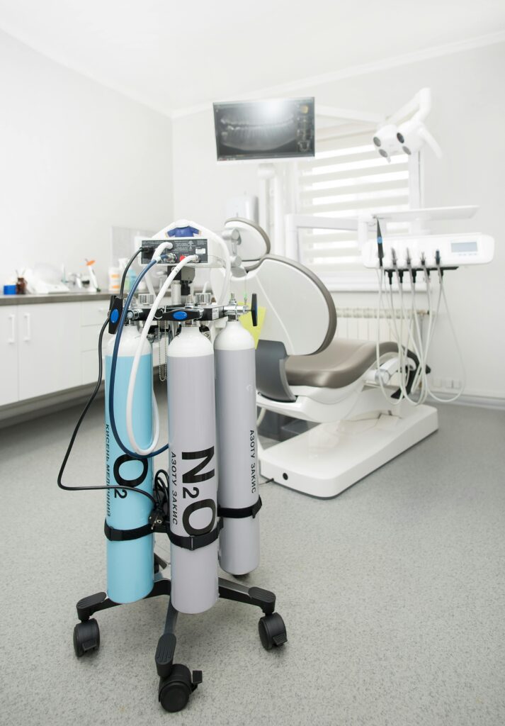 Bright dental clinic room featuring cutting-edge equipment and medical gas tanks for professional use.